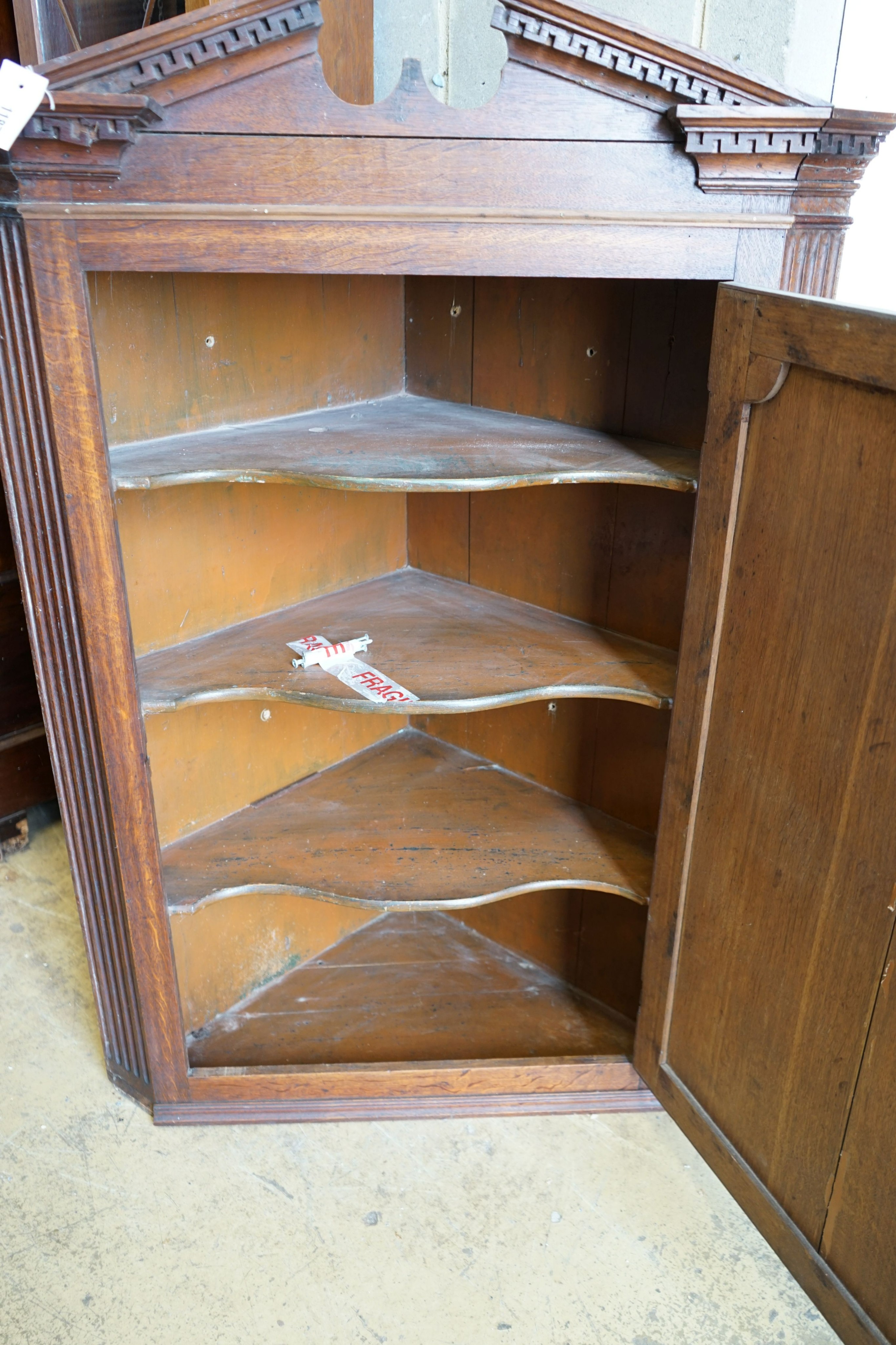 A George III oak hanging corner cabinet, width 85cm, depth 47cm, height 127cm